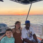 Family of three enjoying a sunset cruise on OC Bay Hopper and they are smiling