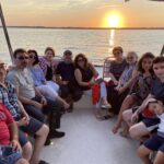 Large Family sitting on boat with a nice sunset in the background