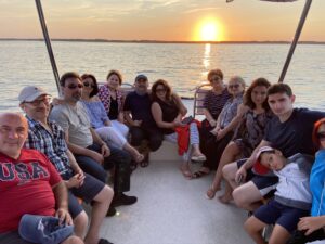 Large Family sitting on boat with a nice sunset in the background