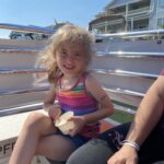 Little girl with a smile eating ice cream on the back of a OC Bay Hopper Pontoon boat.