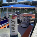 A can of Truly sitting on top of a pier with an OC Bay Hopper in the background