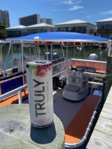 A can of Truly sitting on top of a pier with an OC Bay Hopper in the background