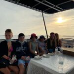 Family enjoying a pizza and a sunset while on a boat