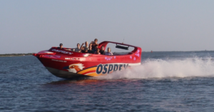 Osprey, a new jet boat or speed boat ride in Ocean City. Showing the bright red boat cruising at high speeds with passengers on board.